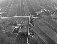 Luchtfoto van de kruising van de T16 (van links naar rechts, de tertiaire provinciale weg Houten-Culemborg) met de Leedijk te Houten op maandag 5 april 1976. Bron: Het Utrechts Archief, catalogusnummer: 847537.