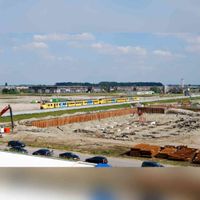 Een materieel '64 treinstel van de Nederlandse Spoorwegen komt langs het toekomstige Houten Castellum in 2009 waarbij ze de parkeergarage aan het uitgraven zijn. Gezien vanaf de woontoren aan de Wijnbouw. Foto: Frank Bosch.