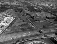 Luchtfoto van de Maarschalkerweerd te Utrecht, uit het zuidoosten. Op de voorgrond de A27, links een gedeelte van de wijk Lunetten en in het midden de spoorlijn naar Arnhem in 1990. Bron: Het Utrechts Archief, catalogusnummer: 85446.