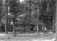 Gezicht op de zijgevel en het terras van het theehuis Rhijnauwen te Bunnik tussen 1921 en 1930. Bron: Het Utrechts Archief, catalogusnummer: 41116.