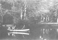Op de achtergrond de hoofdingang van het huis. Op de voorgrond een roeiboot met daarin het gezin van Arie Knoppers, werkman op Rhijnauwen.