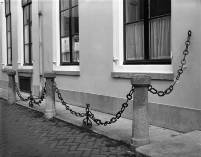 Gezicht op een met stoeppalen en een ijzeren ketting afgezette stoep voor het pand Plompetorengracht 5 in 1983 te Utrecht. Bron: Het Utrechts Archief, catalogusnummer: 815772.