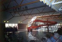 Gezicht op het grote bad in zwembad De Spil met op de achtergrond de rode indoorglijbaan in de periode 1987-1990. Uit de collectie van Cees van Liempt. Bron: Regionaal Archief Zuid-Utrecht (RAZU), 234, 353.