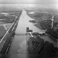 Luchtfoto van de samenvoeging van het Lekkanaal (links) en het Amsterdam-Rijnkanaal bij Nieuwegein, uit het zuiden. Rechts de Plofsluis met de Heemstederbrug in de T20 (de noordelijke uitvalsweg Nieuwegein); links de Overeindsebrug op donderdag 30 september van het jaar 1976. Bron: Het Utrechts Archief, catalogusnummer: 847550.