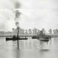 Afbeelding van een baggermolen voor het baggeren van grind en een sleepboot van de N.S. bij Grinderij Linne te Linne in augustus 1956. Bron: Het Utrechts Archief, catalogusnummer:	 154242.