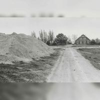 Zicht op de oprijlaan van boerderij Felixhoeve met op de achtergrond met links de zandhopen van de aanleg van de noordwestelijke Rondweg in 1984. Bron: Regionaal Archief Zuid-Utrecht (RAZU), 353.
