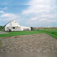 Gezicht op een schuur, behorend bij de boerderij Beusichemseweg 12 te Houten, met op de achtergrond de oprukkende nieuwbouw op 13 augustus 2000. Bron: Het Utrechts Archief, catalogusnummer: 843744.