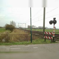 De spoorwegovergang in de Staatslijn H (Utrecht-'s-Hertogenbosch) in zuidelijke richting gezien op de Mereveldseweg bij de gemeentegrens van Bunnik en Houten in 2009. Foto: Sander van Scherpenzeel.