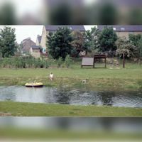 Gezicht op de watergang tussen de Hoge Berg in het Imkerspark bij het Imkerspad met op de achtergrond de woningen aan de Pelgrimsborch/Riddersborch in 1990-1993. Bron: Regionaal Archief Zuid-Utrecht (RAZU), 353.