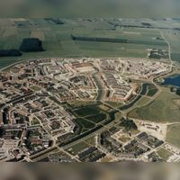 Luchtfoto gezien vanuit het zuidwesten met het Kooikerspark met de buurten De Weiden, De Velden, De Sloten met middenonder de buurt De Gilden in 1988-1991. Bron: RAZU, 353.