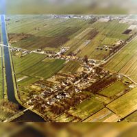 Luchtfoto van het dorp Tull vanuit het zuiden. Links op de foto het Inundatiekanaal, in het midden de Lange Uitweg met rechts de Achterdijk en links de Waalseweg in 1982. Bron: Regionaal Archief Zuid-Utrecht (RAZU), 353.