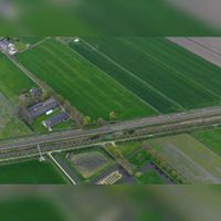 Luchtfoto gezien vanuit het zuidwesten in 2019 met diagonaal (v.l.n.r) de spoorlijn Staatslijn H (Utrecht-'s-Hertogenbosch). Onderaan op de foto het kasteelterrein Schalkwijk. LInksboven de slotlaan of Slotsteeg. Parallel naast de spoorweg de Tetwijkseweg. Foto: Slagboom en Peeters Luchtfotografie B.V..