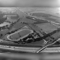 Luchtfoto van de renbaan Mereveld te Utrecht, uit het noordwesten. Op de voorgrond de A27, links de spoorlijn naar Arnhem en op de achtergrond de A12 en het fort Vechten te Bunnik in 1990. Bron: Het Utrechts Archief, catalogusnummer: 85445.