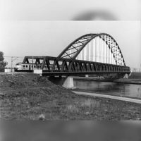 De Schalkwijkse Spoorbrug gezien vanaf de Schalkwijkseweg bij de Schalkwijksebrug met een Mat'64 treinstel onderweg naar Geldermalsen in 1980-1985. Bron: Reionaal Archief Zuid-Utrecht (RAZU), 353.