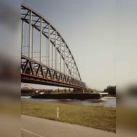 Gezicht op de Schalkwijkse Spoorbrug aan de kant van Houten gezien met een IC richting 's-Hertogenbosch en een onderdoorvarend binnenvaartschip. Rond 1990. Bron: Regionaal Archief Zuid-Utrecht (RAZU), 353.