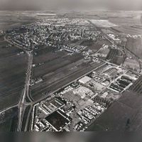 Luchtfoto van het dorp Houten vanuit het zuidoosten gezien met middenonder caravan groothandel Frans de Witte. Nu bedrijfsterrein De Schaft. Midden de Loerikseweg/Beusichemseweg. Rechtsboven de Staatslijn H (Utrecht-'s-Hertogenbosch) in 1979-1980. Bron: HUA, 1929.