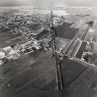Luchtfoto gezien vanuit het zuidoosten met de Staatslijn H (Utrecht-'s-Hertogenbosch) met links het bedrijfsterrein De Schaft met met de Schaftweg en de Albers Pistoriuslaan. Linksboven het dorp Houten in de jaren zeventig. Bron: HUA, 1929.