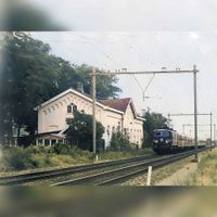 Een 1100 serie locomotief passeert het oude Station Houten in de periode 1960-1970. Afbeelding digitaal ingekleurd en gerestaureerd. Bron: Regionaal Archief Zuid-Utrecht (RAZU), 353.