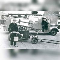 Op de voorgrond de oude brandspuitwagen van de gemeente Houten bij de brandweerkazerne bij de Oranje Nassauweg. Op de achtergrond het nieuwe brandweermaterieel in de periode 1960-1970. Bron: Regionaal Archief Zuid-Utrecht (RAZU), 353.