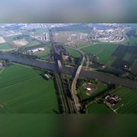 Luchtfoto vanuit het zuiden gezien van de Staatslijn H (Utrecht-'s-Hertogenbosch-Boxtel) en de Schalkwijkse Spoorbrug en de Schalkwijksebrug met Houten Zuid nog in ontwikkeling in 2003-2004. Bron: Collectie Nederland.