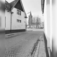 Gezicht op het Plein te Houten, vanuit de Koningin Julianastraat, met op de achtergrond de Nederlands-Hervormde kerk (Lobbendijk 1) in 1975. Bron: Het Utrechts Archief, catalogusnummer: 857010.