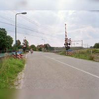 Gezicht op de spoorwegovergang in de Albers Pistoriusweg te Houten richting het zuidoosten gezien op zondag 13 augustus 2000. Spoorwegovergang is per januari 2001 opgeheven in verband met de opening van de tramlijn Houten - Houten Castellum (2001-2008). Bron: Het Utrechts Archief, catalogusnummer: 843742.