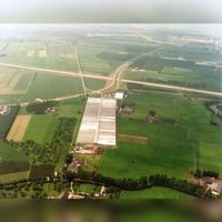 Luchtfoto van Oud Wulven te Houten, uit het oosten, met in het midden het kassencomplex van Tuincentrum Jongerius (Utrechtseweg 19a). Op de voorgrond de Oud Wulfseweg en op de achtergrond de in aanleg zijnde A27 in 1980. Bron: Het Utrechts Archief, catalogusnummer: 85642.
