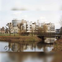 Het fietspad over het water is de Lobbendijk door het Imkerspark. De gebouwen die je ziet, staan aan Het Kant. Het gebouw aan het water is De Imker, april 1992, Regionaal Archief Zuid-Utrecht, identificatienummer: Doos 8 (041368).
