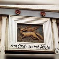 Afbeelding van de gevelsteen, voorstellende een vos met een vogel in zijn bek, boven de ingang van het sigarenmagazijn 