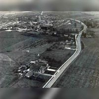 Luchtfoto van de Utrechtseweg gezien vanuit het westen in ca. 1970. Linksonder boerderij Den Oord met het open veld waar de gelijknamige wijk later gebouwd zou gaan worden. Colletie: Gemeente Houten.