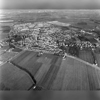 Luchtfoto van Houten, met op de voorgrond de T16 (Utrechtseweg - Schalkwijkseweg), de tertiaire provinciale weg Houten-Culemborg, uit het zuidwesten in december 1980. Bron: Het Utrechts Archief, catalogusnummer: 847542.