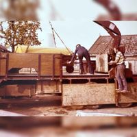 Gezicht op de verhuizing van familie De Vor in 1978 naar de nieuwe boerderij Nieuwoord in Nieuwkoop (bij Alphen aan de Rijn) waarbij de heer Cor van Rijswijk bezig is goederen op de vrachtwagen aan het laden. Bron: met dank aan Henk de Vor.