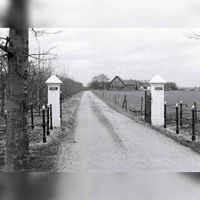 Het toegangshek aan de Tuurdijk van boerderij Koningsbergen met op de achtergrond de boerderij in 1985. Foto: O.J. Wttewaall. Bron: RAZU, 353.