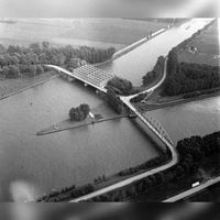 Luchtfoto van de samenvoeging van het Lekkanaal (rechts) en het Amsterdam-Rijnkanaal bij Nieuwegein, uit het noordwesten. Links boven de Plofsluis met de Heemstederbrug in de T20 (de noordelijke uitvalsweg Nieuwegein); rechts onder de Overeindsebrug op 30 september 1976. Bron: HUA, catalogusnummer: 847549.